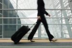 a lady walking with her suit case inside an airport